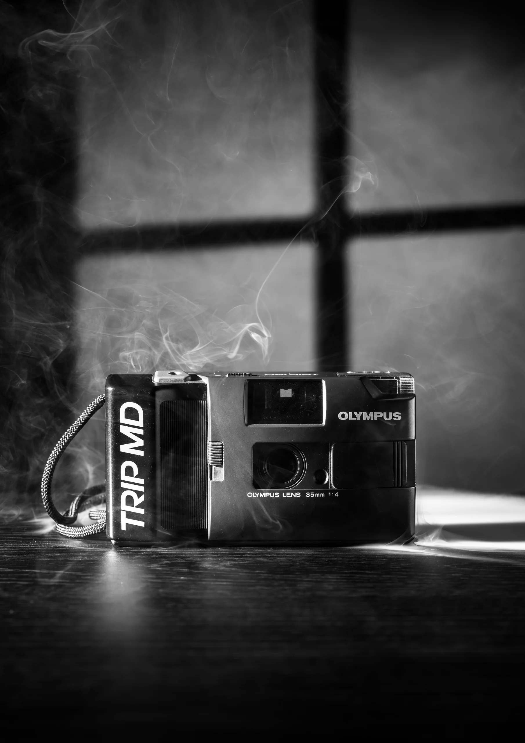 Zwart-wit stilleven van een Olympus Trip MD in rook