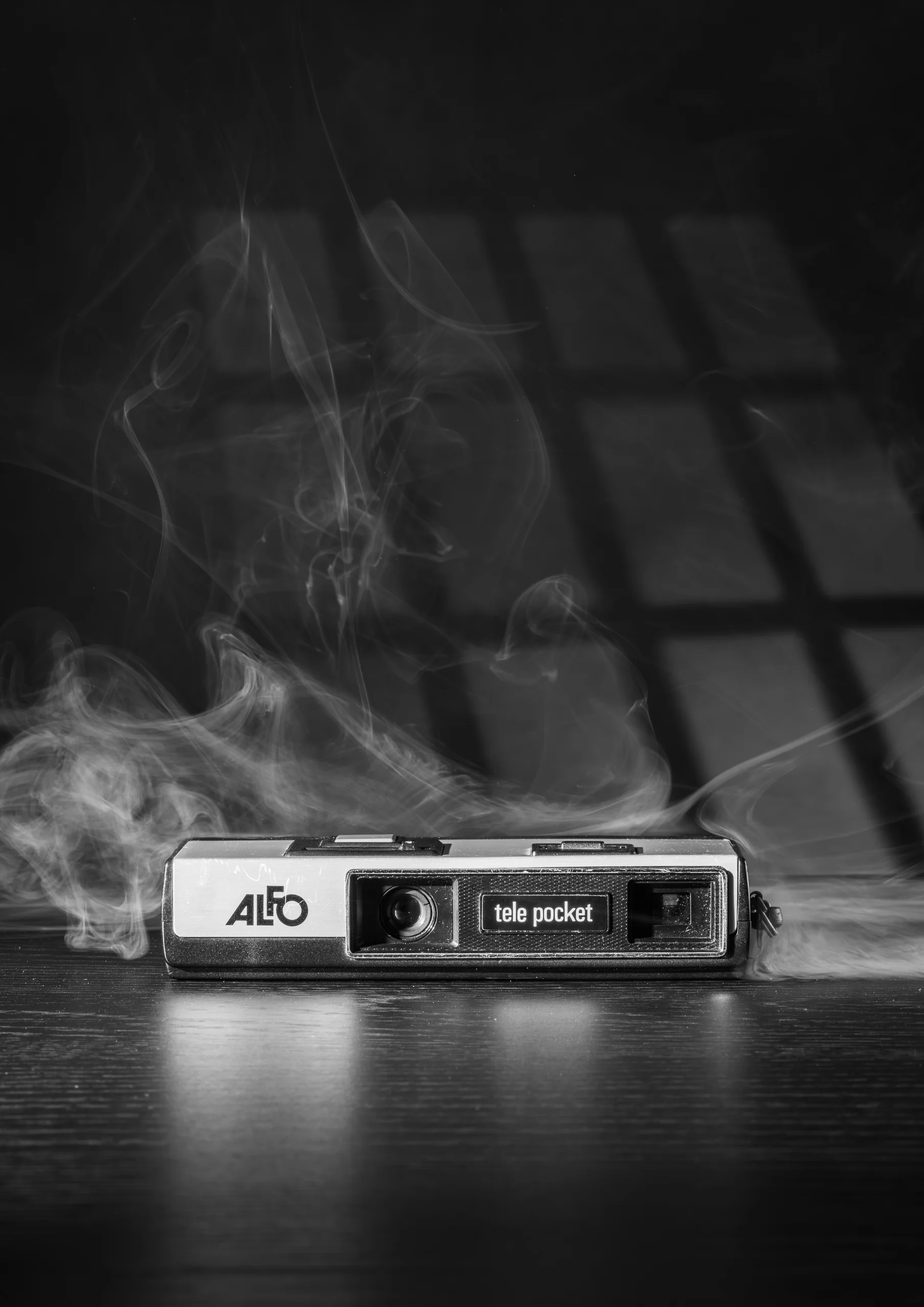 Zwart-wit stilleven van een pocketcamera in rook