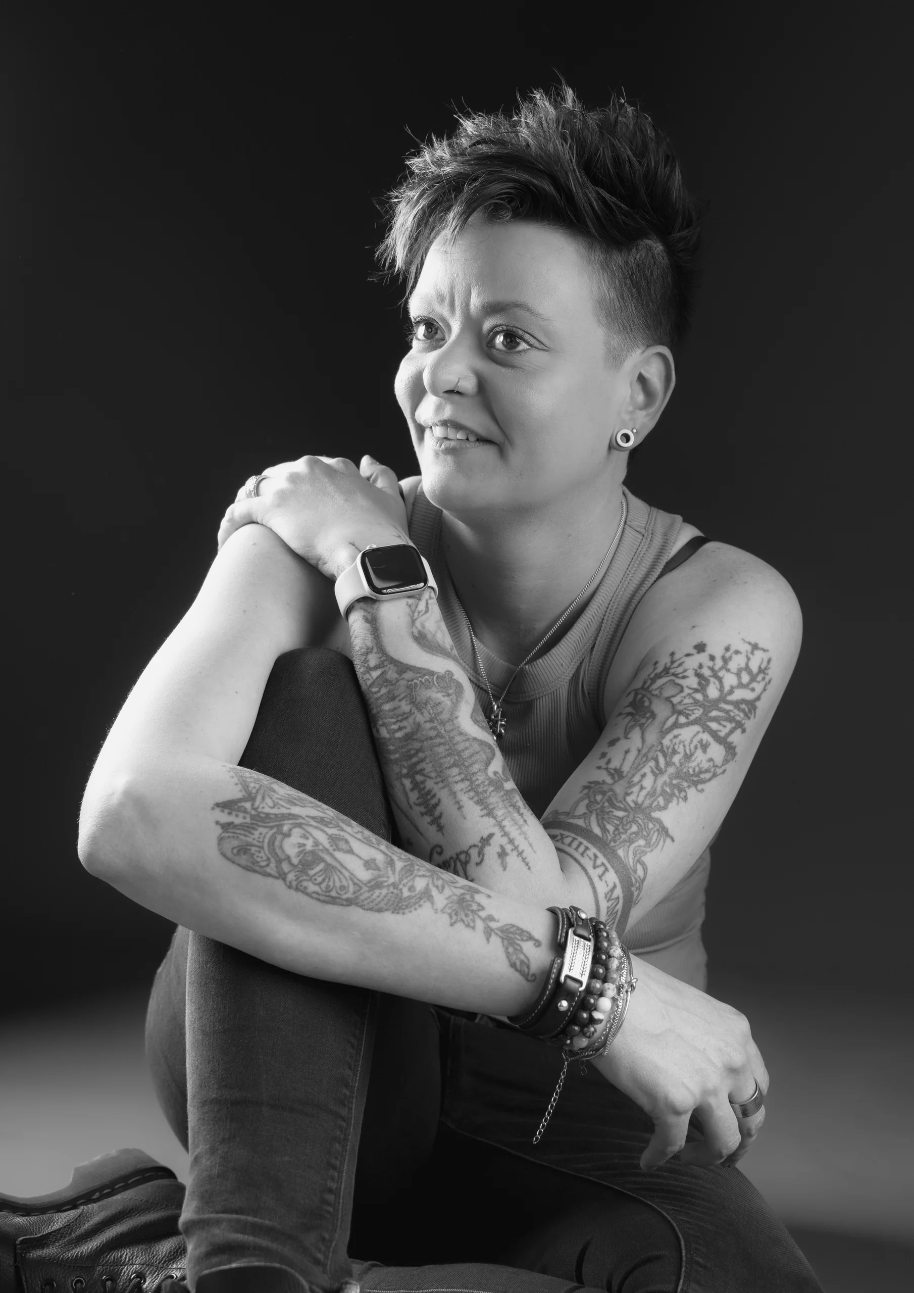 Zwart-witportret van een vrouw met getatoeëerde armen