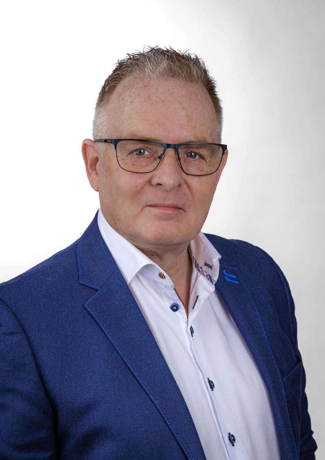 Zakelijk portret van een man met bril in een blauwe blazer